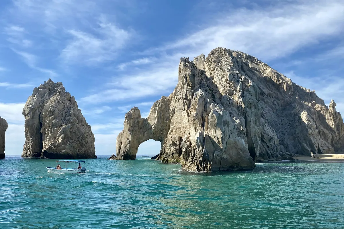 The granite arch at Land's End rising from turquoise water
