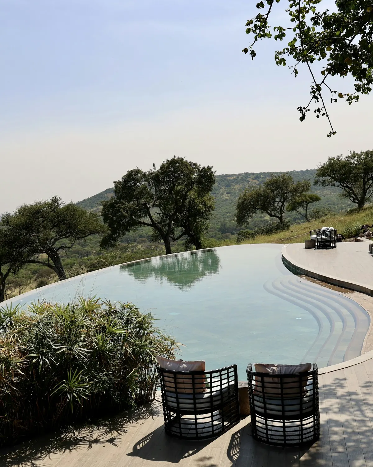 An infinity pool at a hillside resort looking out to the hills